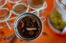 Load image into Gallery viewer, Picture showing SpiceFix Chai Masala blend after brewing in a filter next to glasses filled with chai / tea