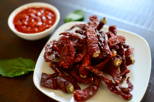 SpiceFix dried red Kashmiri Whole Chilies in a plate next to chili paste made using SpiceFix dried red Kashmiri Whole Chilies